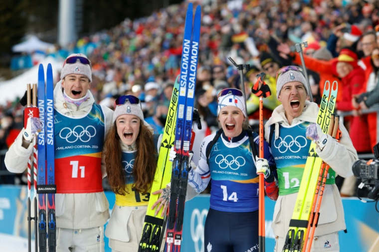 (De gauche à droite): Éric Perrot, Lou Jeanmonnot, Julia Simon et Quentin Fillon Maillet après leur titre sur le relais mixte des JO-2026, à Anterselva, en Italie, le 8 février 2027 ( AFP / Odd ANDERSEN )