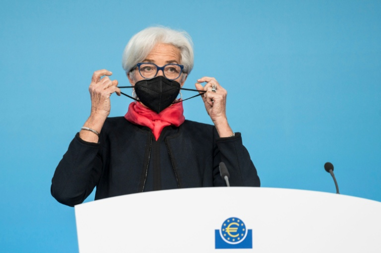 La présidente de la BCE Christine Lagarde retire son masque de protection pour s'exprimer lors d'une conférence de presse à Francfort, le 16 décembre 2021 pendant la période du Covid ( POOL / Thomas Lohnes )