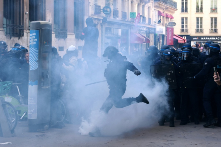 Un policier donne un coup de pied dans une grenade lacrymogène lors d'une manifestation de lycéens place de la Bastille à Paris, le 8 octobre 2026 ( AFP / Kenzo TRIBOUILLARD )