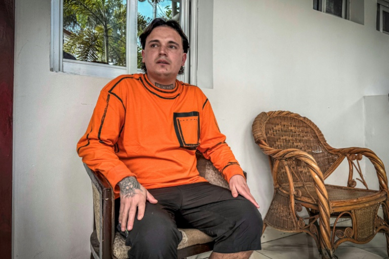Hugo Palencia Ropero, 25 ans, ressortissant colombien expulsé des États-Unis vers la République démocratique du Congo (RDC), est assis devant sa chambre d'hôtel à Kinshasa le 22 avril 2026 ( AFP / Glody MURHABAZI )