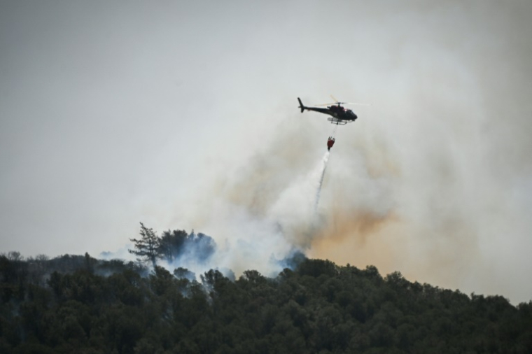 Un hélicoptère bombardier d'eau lutte contre un feu de forêt près de Narbonne, le 8 juillet 2025 dans l'Aude ( AFP / Matthieu RONDEL )
