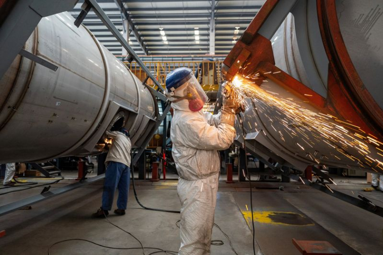 Des ouvriers travaillent sur une chaîne de montage dédiée à la fabrication de conteneurs-citernes dans une usine de Nantong