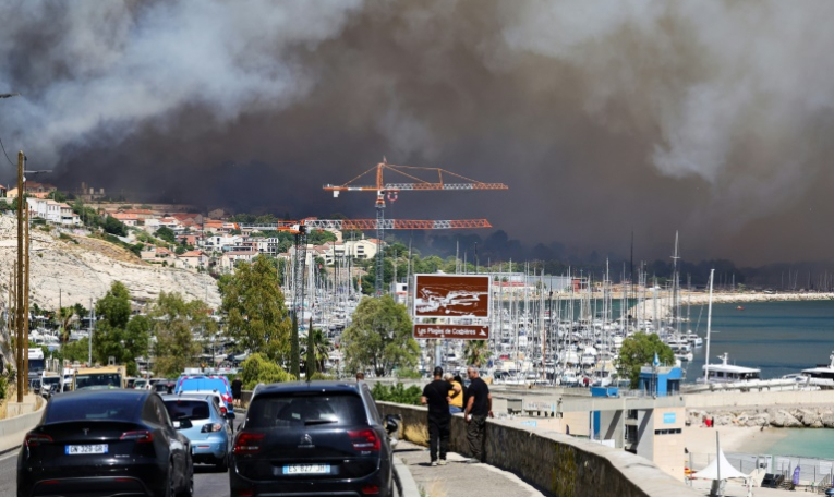 Le nuage de fumée d'un incendie près de la Plage des Corbières à Marseille, le 8 juillet 2025 ( AFP / CLEMENT MAHOUDEAU )
