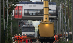 Des grues relèvent une voiture d'un train qui a déraillé, à Cléon, en Seine-Maritime, le 16 septembre 2026  ( AFP / GUILLAUME SALIGOT )