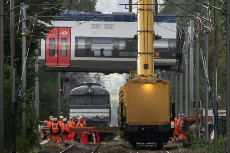 Des grues relèvent une voiture d'un train qui a déraillé, à Cléon, en Seine-Maritime, le 16 septembre 2026  ( AFP / GUILLAUME SALIGOT )