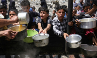 Des déplacés palestiniens se rassemblent pour collecter des repas gratuits auprès d'une association caritative à Jabalia, dans le nord de la bande de Gaza, le 19 mai 2025 ( AFP / Bashar TALEB )
