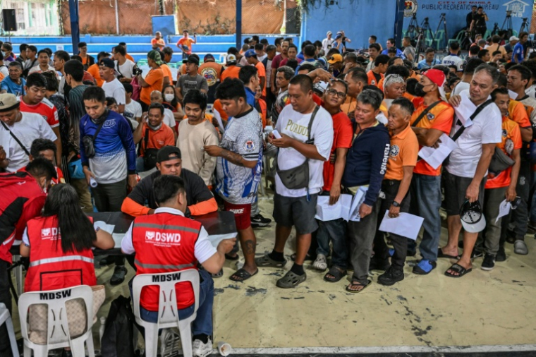 Des conducteurs de tricycles font la queue pour la distribution d'une subvention sur le carburant à Manille, le 17 mars 2026 aux Philippines ( AFP / Jam STA ROSA )
