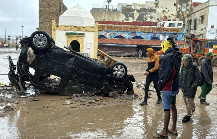 Des Marocains regardent un véhicule renversé et d'autres débris après une crue soudaine, dans la ville côtière de Safi, à environ 300 kilomètres au sud de la capitale Rabat, le 15 décembre 2025 ( AFP / - )