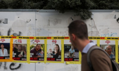 Un homme passe devant des photos de la famille Bibas, à Jérusalem