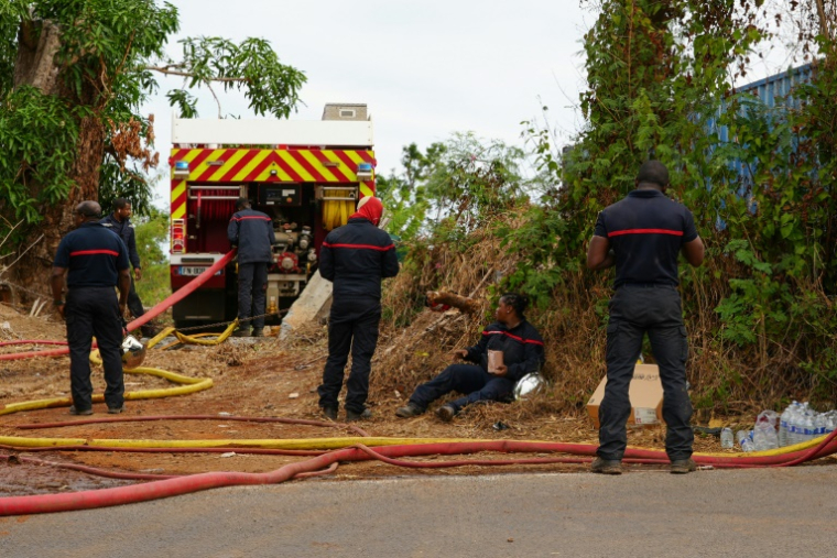 Des pompiers tentent d'éteindre un feu provenant de cultures sur brûlis, au village d'Inroni Bé, Mayotte, le 12 août 2025 ( AFP / Marine GACHET )