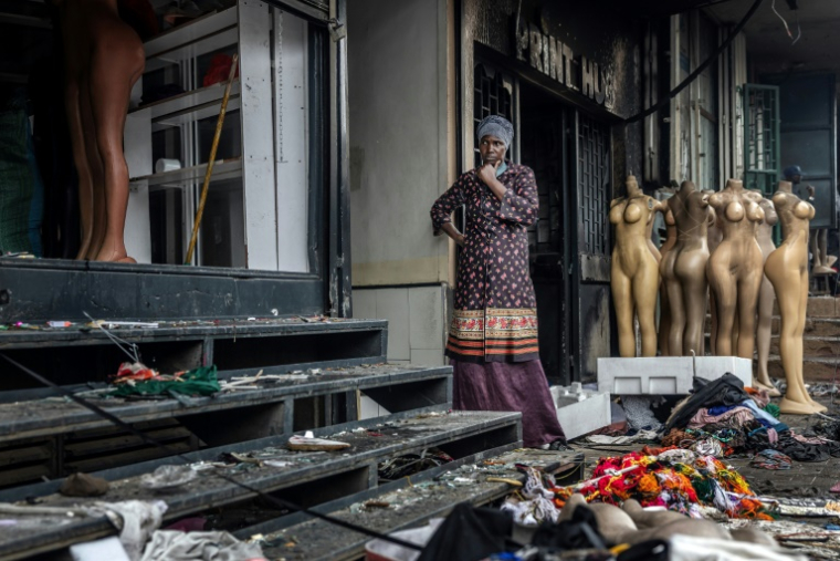Une propriétaire devant sa boutique incendiée et vandalisée au lendemain de manifestations violentes marquant les commémorations du premier anniversaire de la prise du Parlement, le 26 juin 2025 à Nairobi, au Kenya ( AFP / Luis TATO )