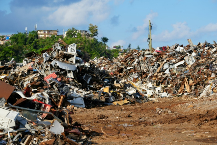 Un terrain jonché de débris et de tôles métalliques à Mamoudzou, un an après le passage du cyclone Chido à Mayotte, le 2 décembre 2025 ( AFP / Marine GACHET )