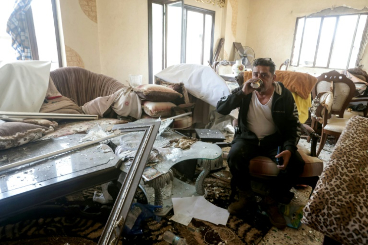 Un homme boit du thé dans sa maison endommagée après être revenu, au lendemain d'un cessez-le-feu avec Israël, dans sa ville natale de Qana, dans le sud du Liban, le 18 avril 2026  ( AFP / MAHMOUD ZAYYAT )