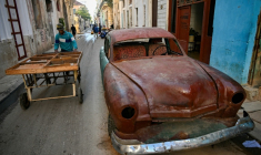 Un homme pousse une charrette près d'une vieille voiture dans une rue de La Havane, le 4 mai 2026 ( AFP / YAMIL LAGE )