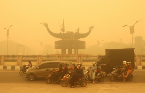 Des motocyclistes portant un masque de protection circulent dans une épaisse brume causée par des feux de forêt et de terres dans la région de Palangkaraya, dans le Kalimantan central, le 24 octobre 2026 en Indonésie ( AFP / REINA )