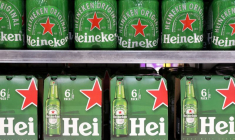 Des bouteilles de bière Heineken sont exposées sur une étagère dans un supermarché.