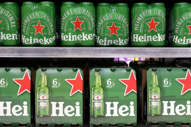 Des bouteilles de bière Heineken sont exposées sur une étagère dans un supermarché.