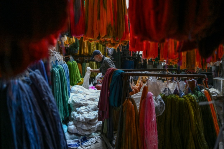 Un ouvrier trie des fils de soie dans un atelier traditionnel de teinture à Srinagar, le 1er novembre 2025 ( AFP / Tauseef MUSTAFA )
