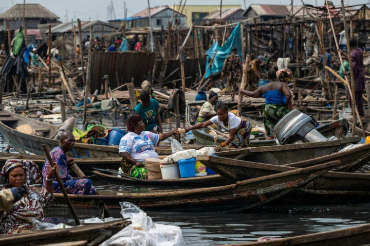 AUne habitante vend des aliments de base depuis une pirogue lors de la démolition de maisons du bidonville flottant de Makoko, le 9 janvier 2026 à Lagos, au Nigeria ( AFP / TOYIN ADEDOKUN )