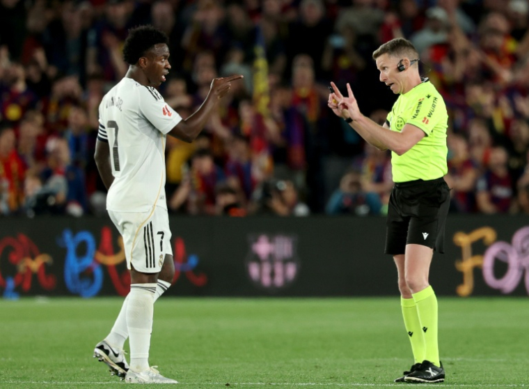 L'attaquant du Real Madrid Vinicius Junior en discussion avec l'arbitre du Clasico Alejandro Hernandez, le 10 mai 2026 au Camp Nou ( AFP / Lluis GENE )