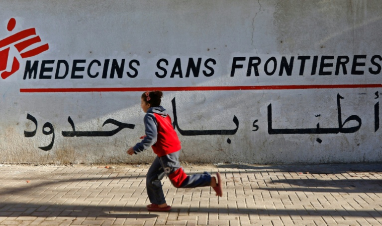 Une enfant palestinienne passe en courant devant la clinique de Médecins Sans Frontières (MSF), dans le quartier d'al-Rimal, à Gaza, le 11 janvier 2026 ( AFP / Omar AL-QATTAA )
