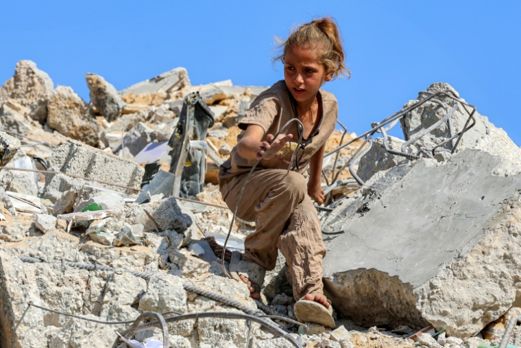Une fille cherche des objets récupérables sur un tas de décombres sur le site de l’effondrement de la tour Soussi, détruite plus tôt par un bombardement israélien, dans la ville de Gaza le 6 septembre 2025 ( AFP / Omar AL-QATTAA )