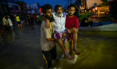 De jeunes hommes portent une personne âgée dans une rue inondée de Wellampitiya, dans les faubourgs de Colombo, la capitale du Sri Lanka, le 30 novembre 2025 ( AFP / Ishara S. KODIKARA )