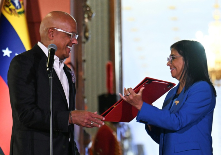 La présidente par intérim du Venezuela Delcy Rodriguez se voit remettre la loi d'amnistie par le président de l'Assemblée nationale Jorge Rodriguez, le 19 février 2026 au palais de Miraflores à Caracas ( AFP / Juan BARRETO )