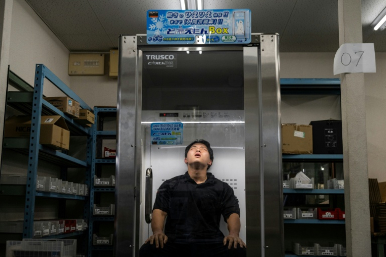 Taichi Konishi, employé de la société Konoe, fait une pause dans la cabine réfrigérée commercialisée par Trusco Nakayama, à Higashiosaka, dans la préfecture d'Osaka, le 21 août 2026 ( AFP / ANDREW CABALLERO-REYNOLDS )