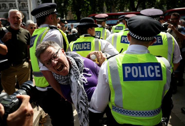 Un manifestant est emmené par des policiers lors d'une manifestation « Lift The Ban » (Lève l'interdiction) en soutien au groupe interdit Palestine Action, qui réclame la levée de l'interdiction récemment imposée, sur Parliament Square, dans le centre de Londres, le 9 août 2025 ( AFP / HENRY NICHOLLS )
