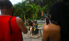 Une touriste pose à côté de la statue de Brigitte Bardot, à Buzios, au Brésil, le 3 janvier 2026 ( AFP / MAURO PIMENTEL )