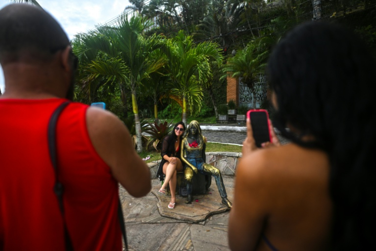 Une touriste pose à côté de la statue de Brigitte Bardot, à Buzios, au Brésil, le 3 janvier 2026 ( AFP / MAURO PIMENTEL )