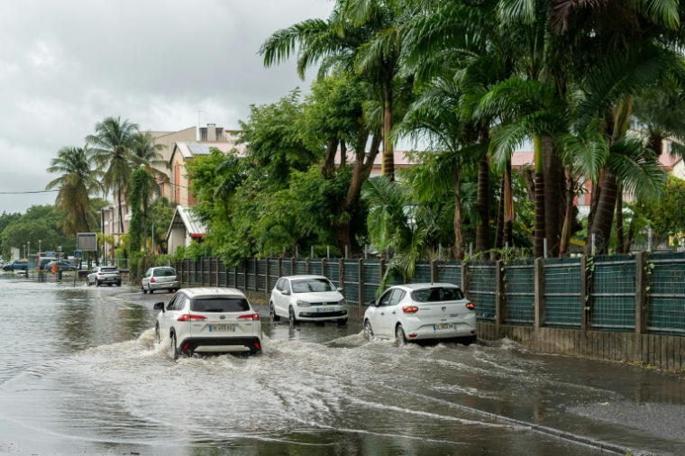 Un automobiliste dans une rue inondée par des fortes pluies causées par la tempête tropicale Jerry, à Lauricisque, en Guadeloupe, le 10 octobre 2025 ( AFP / Cedrick Isham CALVADOS )