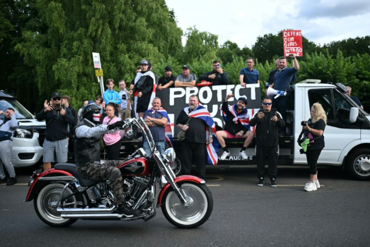 Des manifestants anti-immigration rassemblés près du Bell Hotel, hébergeant des demandeurs d'asile, à Epping, au nord-est de Londres, le 20 juillet 2025 ( AFP / JUSTIN TALLIS )