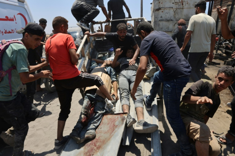 Des Palestiniens transportent des hommes blessés alors qu'ils attendaient de l'aide humanitaire, à Jabalia dans le nord de la bande de Gaza, le 22 juin 2025 ( AFP / Omar AL-QATTAA )