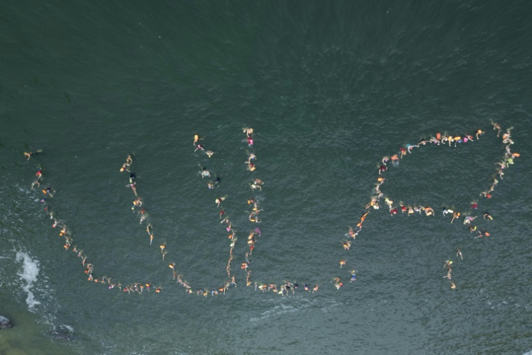 Vue aérienne de partisans du président sortant et candidat à la présidentielle, Luiz Inácio Lula da Silva, formant le mot "Lula" dans l'eau sur la plage Vermelha, à Rio de Janeiro, au Brésil ( AFP / Pablo PORCIUNCULA )