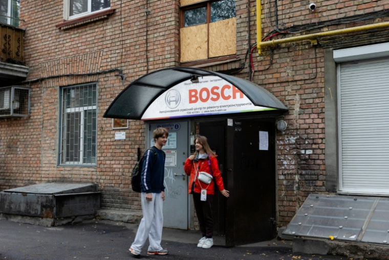 Anastassiia Jmoutskaet son fils Oreste se rendent à l'école après une alerte aérienne, à Kiev, le 13 octobre 2026 en Ukraine ( AFP / Tetiana DZHAFAROVA )