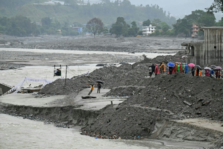 Des personnes attendent pour traverser une rivière avec une tyrolienne, après la crue meurtrière du 26 août, à Nuwakot au Népal le 24 septembre 2026 ( AFP / PRAKASH MATHEMA )