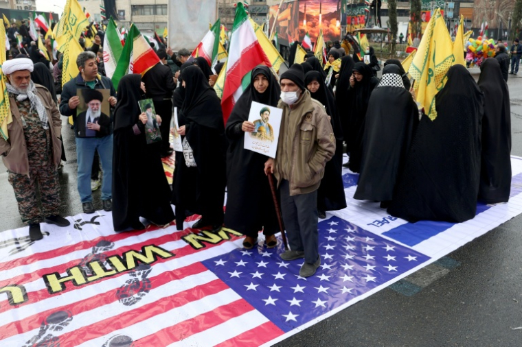 Photo réalisée avec l'accord du ministère de la Culture et de l'Orientation islamique iranien d'Iraniens qui marchent sur un drapeau américain lors d'une commémoration en soutien au peuple palestinien, à Téhéran, le 13 mars 2026 ( AFP / - )