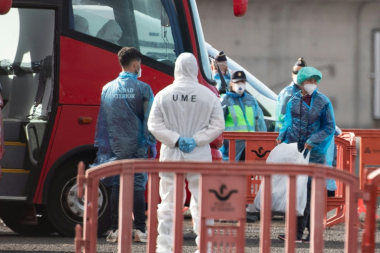 Des passagers (D) du MV Hondius évacués par autobus vers l'aéroport, à Granadilla de Abona, sur l'île de Tenerife, le 10 mai 2026 ( AFP / JORGE GUERRERO )