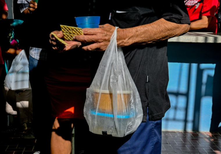 Un Cubain transporte dans un sac un repas gratuit qui vient de lui être distribué à l'église baptiste Nazareth du quartier de La Vibora, à La Havane, le 14 avril 2026 ( AFP / Adalberto ROQUE )