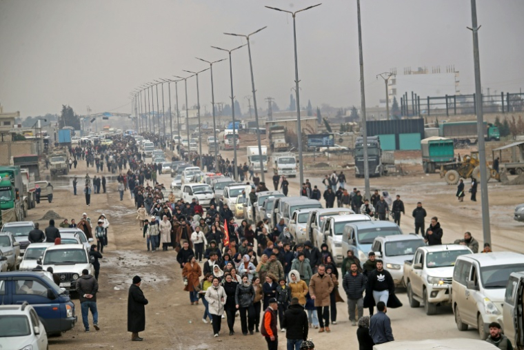 Des habitants accueillent un convoi ramenant des combattants kurdes d'Alep après des jours de combat avec les forces gouvernementales dans la ville syrienne sous contrôle kurde de Qamishli, le 11 janvier 2026 ( AFP / Delil SOULEIMAN )