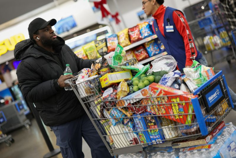 Client avec un chariot de courses chargé dans un magasin Walmart Supercenter à North Bergen, New Jersey
