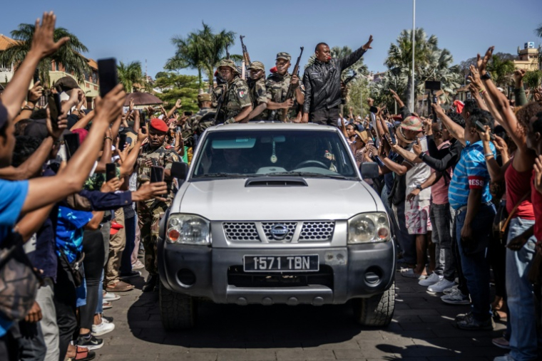 Des membres d'une unité de l'armée malgache ayant appelé à la désobéissance défilent dans un pick-up lors d'une cérémonie d'hommage aux morts des manifestations anti-gouvernemantales à Madagascar, le 12 octobre 2025 à Antananarivo ( AFP / Luis TATO )