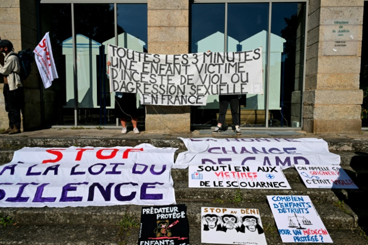 Des banderoles affichées à l'extérieur du palais de justice de Vannes en soutien aux victimes de Joël Le Scouarnec lors de son procès, le 19 mai 2025 ( AFP / Damien MEYER )