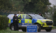 Des policiers armés tiennent un barrage routier alors qu'ils sont en poste devant la base de la RAF de Fairford, dans le sud-ouest de l'Angleterre, le 27 septembre 2026 ( AFP / JUSTIN TALLIS )