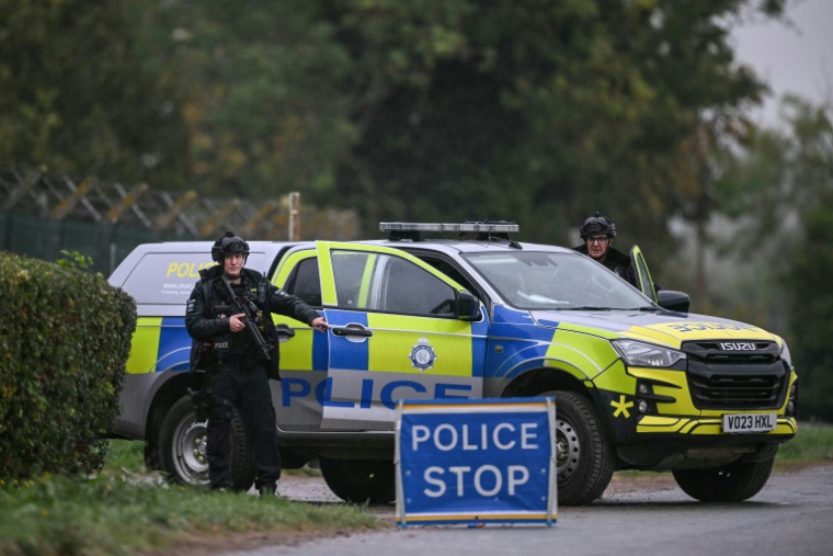 Des policiers armés tiennent un barrage routier alors qu'ils sont en poste devant la base de la RAF de Fairford, dans le sud-ouest de l'Angleterre, le 27 septembre 2026 ( AFP / JUSTIN TALLIS )