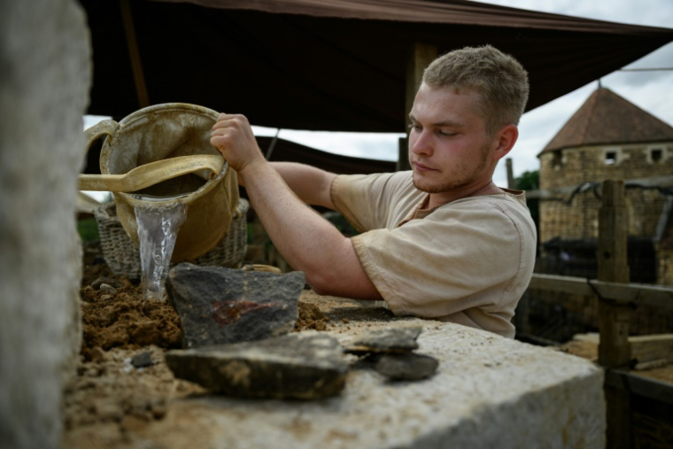 Un ouvrier construit un mur sur le chantier du château de Guédelon à Treigny, le 23 juin 2025 dans l'Yonne ( AFP / ARNAUD FINISTRE )