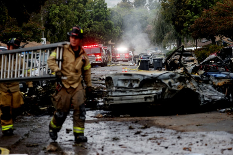 Des pompiers sur le site où s'est écrasé un avion privé, dans un quartier résidentiel de San Diego, en Californie, le 22 mai 2025 ( AFP / Sandy Huffaker )