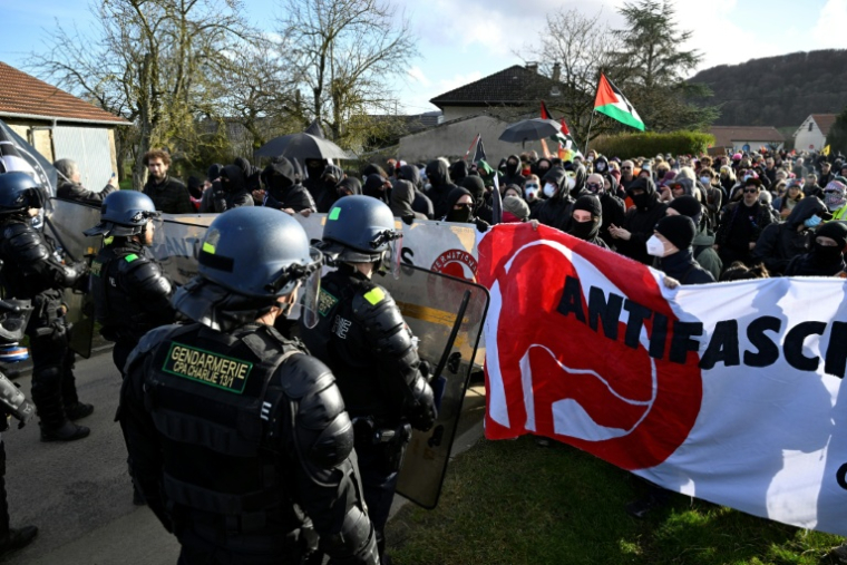 Les membres du collectif “Fermez la!” face aux gendarmes lors d'une manifestation réclamant la fermeture d'un hangar "La Taverne de Thor" où des combats de MMA et des concerts néonazis sont organisés depuis plus de dix ans à Combres-sous-les-Côtes, dans la Meuse, le 7 février 2026 ( AFP / Jean-Christophe VERHAEGEN )
